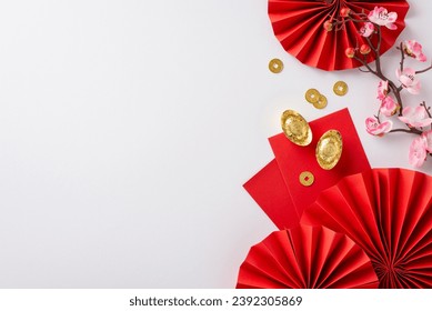 伝統を祝いましょう! 白い背景に赤い扇、風水のシンボル、幸運のコイン、紅包、桜を上から見た図。メッセージや広告に最適です。