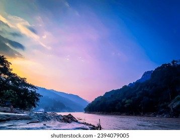 Reflet pittoresque et coloré du ciel crépusculaire sur les eaux du lac Ganga. Coucher de soleil paisible et aube sous une colline de montagne pour une destination touristique en Asie. Crépuscule spectaculaire au printemps