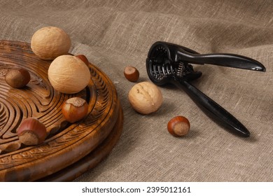 Walnuts and hazelnuts on a wooden board with a nutcracker