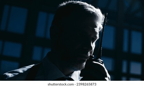 A police detective is giving commands on the radio during an undercover operation, a black op