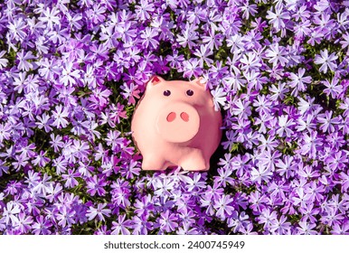 紫色の花を背景にした貯金箱