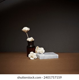 Un difusor con un fondo de papel marrón con un podio cuadrado de mármol y flores blancas. Una plataforma vacía para exhibir productos cosméticos, alimentos y accesorios.
