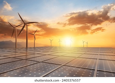 Panel słoneczny i turbina wiatrowa na tle pięknego zachodu słońca, ilustrujące koncepcję czystej energii i zrównoważonych zasobów.