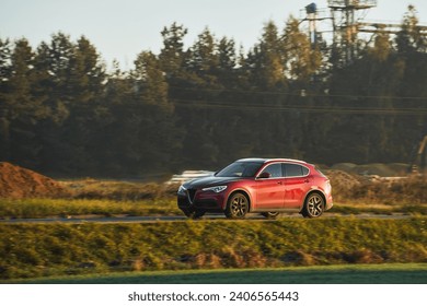 高速道路上の赤い車。夏の夕暮れの道路をスピードと旅で楽しむためのスポーティで豪華な SUV 車。