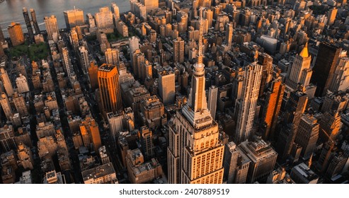 Letecký pohľad na Empire State Building Spire pri západe slnka a turistické observatórium Top Deck. New York City Business Center zhora. Fotografia architektonického zázraku z vrtuľníka v centre Manhattanu