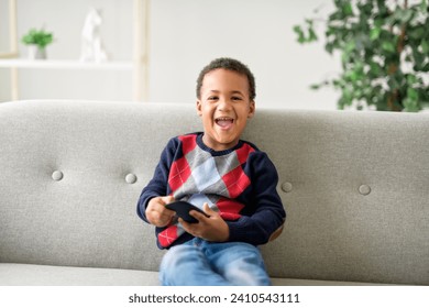 A boy sitting on sofa at home and watching TV