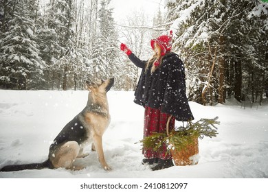 Schéint klengt Meedchen a roude Mutz oder Hut a schwaarze Mantel mat Kuerf vu grénge Firzweige am Schnéibësch a groussen Hondshiert als Wollef um kale Wanterdag. Spaass a Mäerchenbuch op Fotosessioun