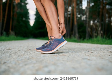 Close-up of female runner touching achilles tendon. Achilles tendonitis injury