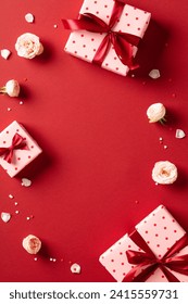 Valentines Day flat lay composition with gift boxes, roses flowers on red background. Flat lay, top view, copy space.