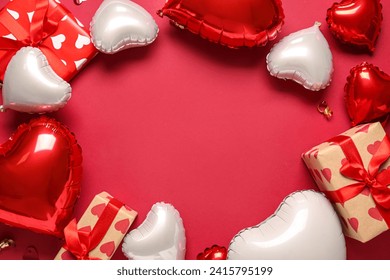 Frame made of heart shaped air balloons and gift boxes on red background. Valentine's Day celebration