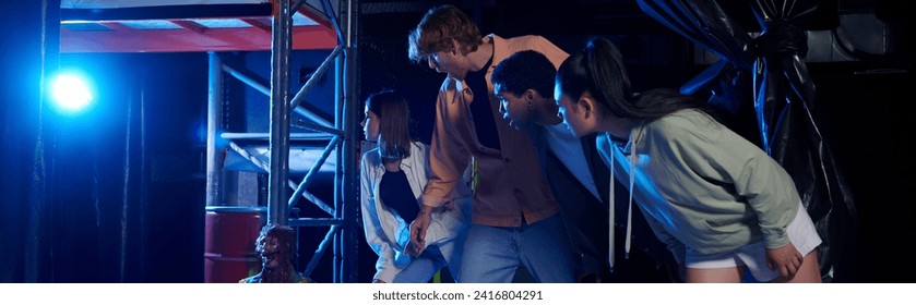 banner of diverse and curious young people looking at scary mannequin during a quest room challenge