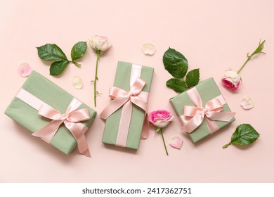Kotak hadiah hijau dan mawar cantik pada latar belakang merah jambu. Hari Wanita Antarabangsa