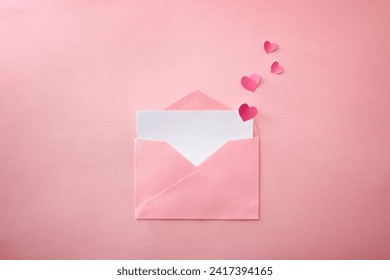 분홍색 질감 배경에 하트 컷아웃이 나온 빈 흰색 시트가 있는 열린 분홍색 봉투. 위에서 본 모습.