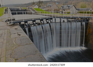 A view of water pouring over the sluice gates on the Caledonian canal at Fort Augustus in the Scottish Highlands.