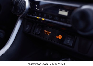 instrumentos de ar condicionado para um novo toyota 4x4 mostrando o airbag do passageiro na cor laranja na parte frontal do carro com botões para modificar o ar em preto e branco metálico