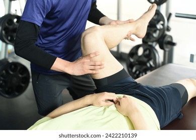 Imagem de um quiroprático massageando as pernas de um quiroprático esportivo
