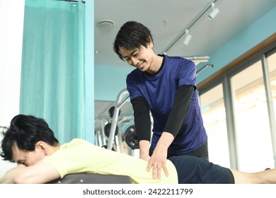 Quiroprático asiático massageando cintura e costas