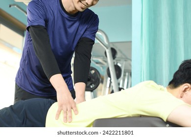 Quiroprático asiático massageando cintura e costas