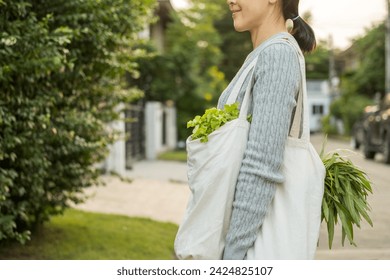 Woman hands holding shopping bag vegetables on the way home. Reusable cotton and mesh eco bags for shopping. Set zero waste plastic free concept. Sustainable lifestyle concept.