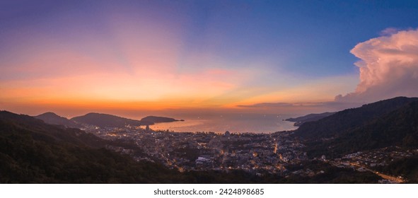 aerial panorama scenery sunset above Patong beach Phuket Scene of Colorful romantic sky sunset with panorama city scape. The lights twinkle at dusk background. nature and travel concept.