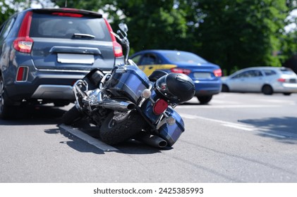 Blue motorcycle lying on road near car closeup. Road traffic accidents with motorcyclists concept