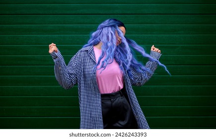 Sretna žena pleše. Djevojka plesačica s kreativnom obojenom kosom i frizurom. Lifestyle fotografija. Cosplay na anime liku.