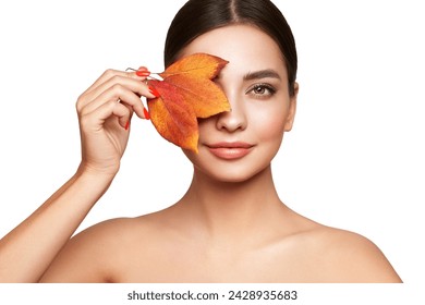 Potret wanita muda cantik dengan daun musim gugur. Kulit sehat, bersih, segar, riasan alami, mata cantik, dan kuku merah