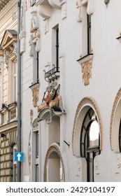 Tenement house under the frogs in the Art Nouveau style. Sculptures depicting 2 frogs in tailcoats. One of them plays the mandolin, the other smokes a pipe.