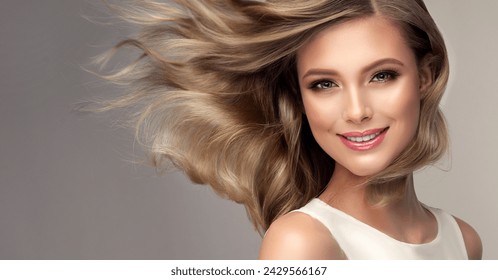 Красиво русо момиче с дълга и лъскава вълниста коса. Красив модел на жена с къдрава прическа. Перм, трихология и грижи