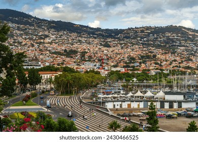 Pemandangan yang tidak biasa dari pelabuhan Funchal, ibu kota Madeira, dengan kota di latar belakang yang menutupi lereng pegunungan.