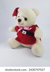 white teddy bear wearing a red costume and a santa claus hat as a Christmas gift for a good child