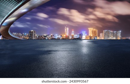 Dataran jalan asfalt dan jambatan dengan latar langit bandar pada waktu malam di Macau