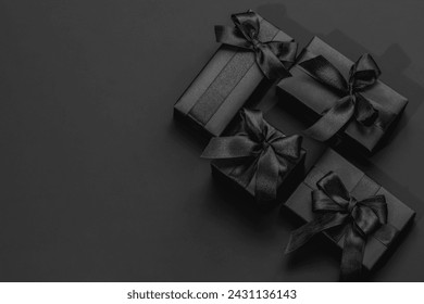 Black gift boxes on a dark black background with space for text. Gifts for him, happy father's day.