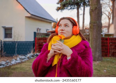 happy girl in bright clothes and headphones with rose flower