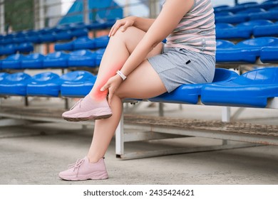 Achilles tendon injury, callus on the heel while running, foot pain, woman suffering from feet ache on a sports ground, podiatry concept