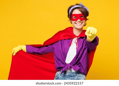 Jonge vrouw draagt ​​paars shirt rubberen handschoenen superheldenpak casual kleding doe huishoudelijk werk ruim op wijs vinger camera op je geïsoleerd op effen gele achtergrond studioportret. Huishoudelijk concept