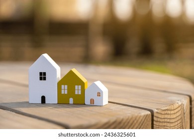 Wooden houses stand in a row outdoors on a sunny day. Real estate and affordable housing concept. Mortgage, loan. Eco-friendly house