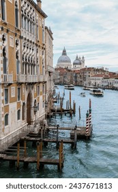 Beautiful interesting view of boats and water buses crossing the iconic Grand Canal in Venice and the Basilica Santa Maria della Salute - Venice, Italy