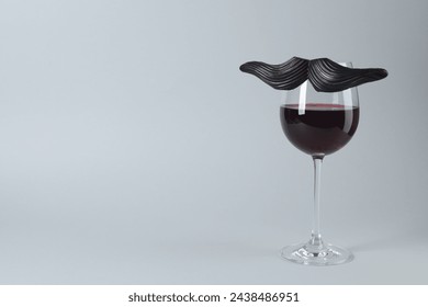Glas roude Wäin mat witzeg gefälschte Moustache op groem Hannergrond, Plaz fir Text