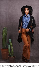 Cactus, Moud oder Fra am Cowgirl, Portrait, Wild West Kultur a cool Kleeder am Studio op groem Hannergrond. Native American Persoun, westlech Dame a stilvoll Modell mat Stolz, Boho Stil oder Planzen