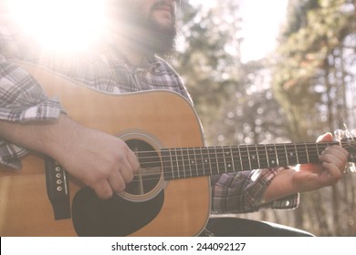 Un músico de folk country tocando su guitarra.