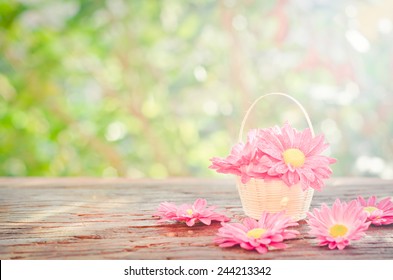 Blumen in einem Korb auf Holz mit Bokeh-Hintergrund im Vintage-Retro-Stil, mit Sonnenaufgang, für den Tag der Liebe, den Valentinstag.