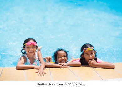 Kanner spillen an der Schwämm. Kanner léieren am Outdoor Pool vum tropesche Resort wärend der Famill Summervakanz ze schwammen. Waasser a Splash Spaass fir jonkt Kand an der Vakanz. Sonneschutz fir Kand a Puppelchen.