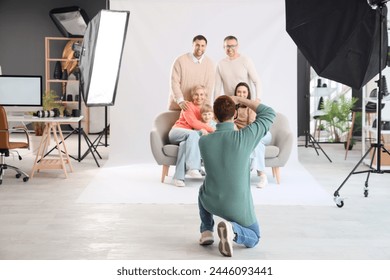 Männlicher Fotograf fotografiert große Familie im Studio, Rückansicht