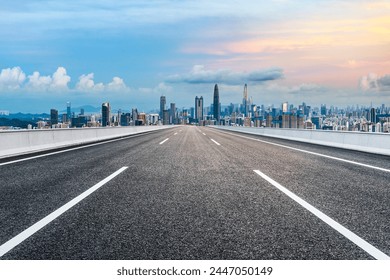 Droga asfaltowa i panoramę miasta z nowoczesnymi budynkami o zmierzchu w Shenzhen
