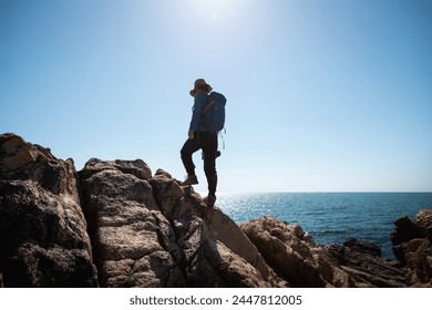 Fotografin genießt den Blick auf die Felsen am Meer bei Sonnenaufgang