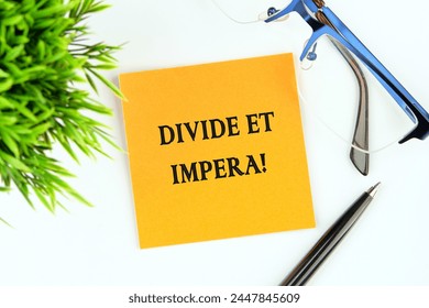 Latince alıntı Divide et impera, Böl ve yönet anlamına gelir. Böyle bir devleti yönetmenin en iyi yöntemi, parçaları arasında düşmanlık kışkırtmak ve kullanmaktır. Turuncu bir çıkartmanın üzerine yazılmış metin