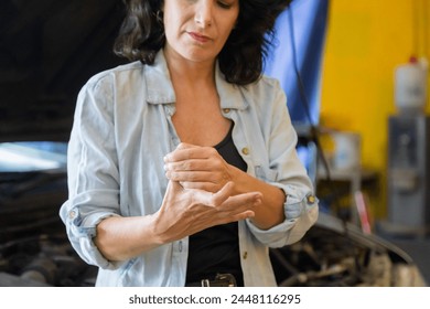 Middle-aged small business entrepreneur female standing arm crossed in front auto repair service shop,   portrait of garage owner woman happy start-up business, automobile technician worker lifestyle