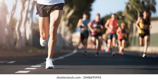 Lari maraton di bawah sinar pagi. Kaki orang-orang di jalanan kota.