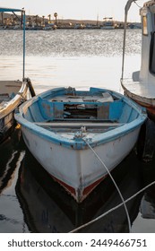 Lesena ladja na vodi v pristanišču. Ribiška ladja na vodi ob sončnem zahodu. Posnetek ribiške ladje od blizu.